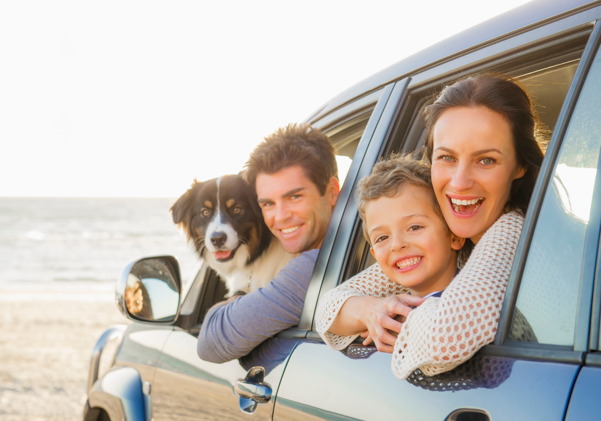 Family sitting in their newly purchased vehicle smiling. 