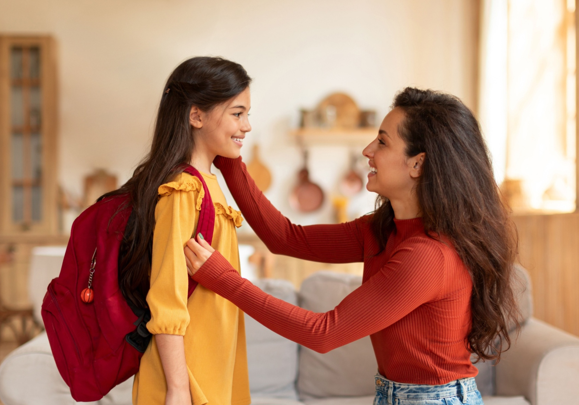 Mother getting daughter ready for first day of school