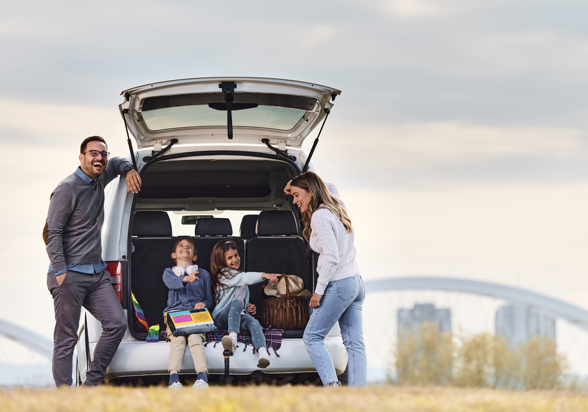 happy family standing next to new SUV