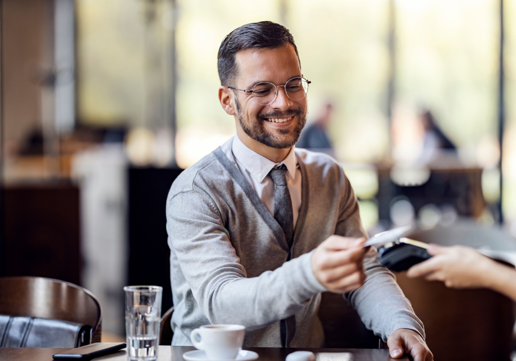 man paying with The Police Credit Union Visa Credit Card at restaurant