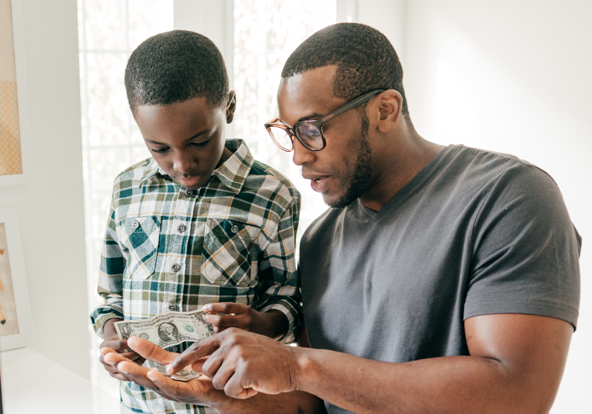father teaching young son how to create a budget