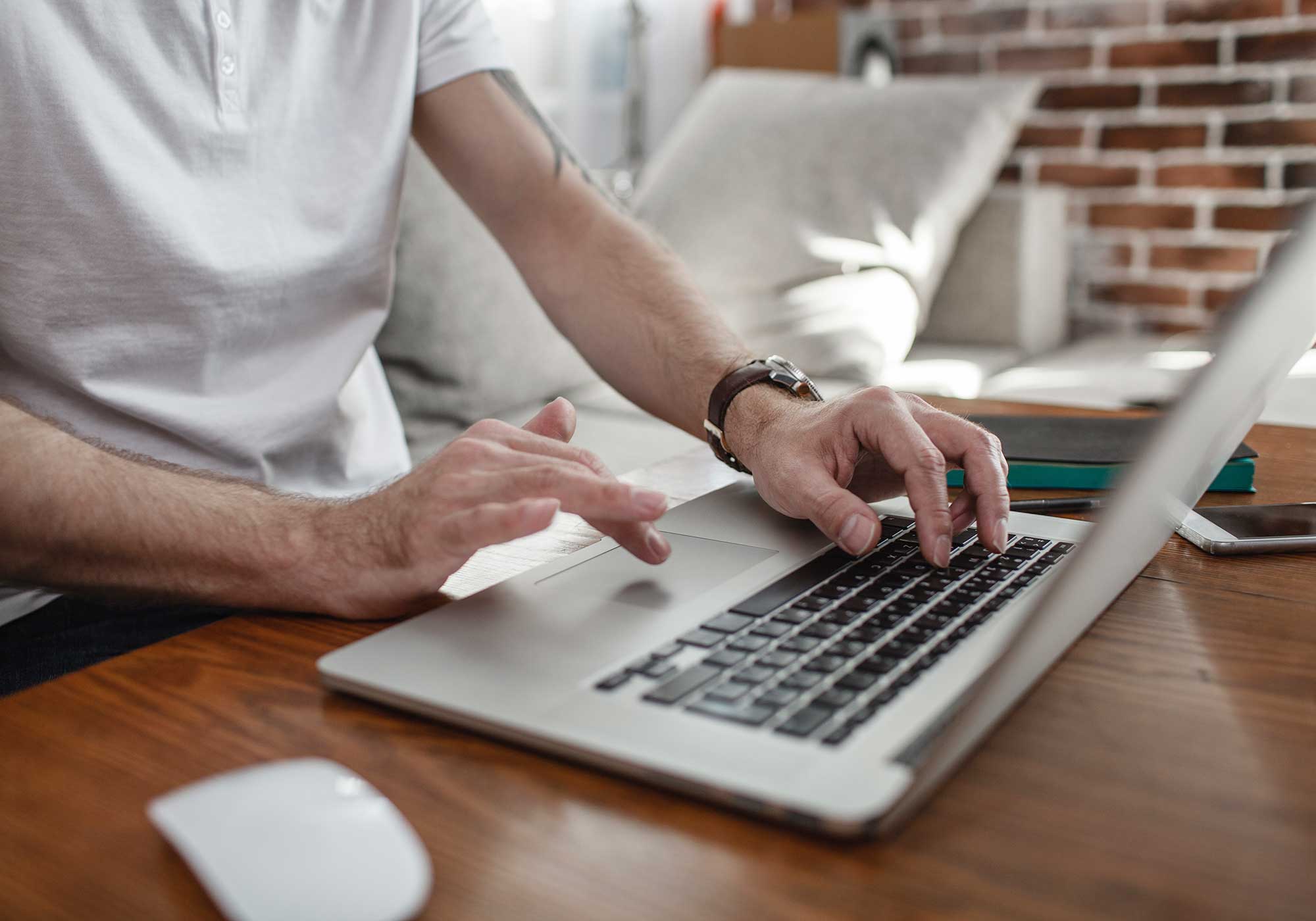 A man sitting while typing on his laptop. 