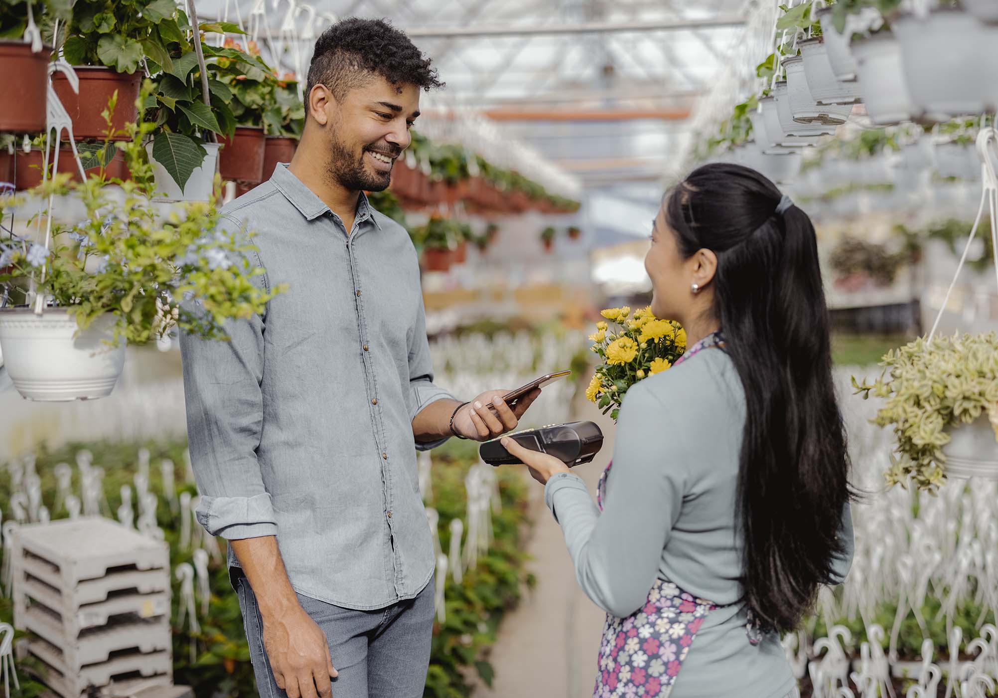 A man at a plant store paying with his digital wallet. 