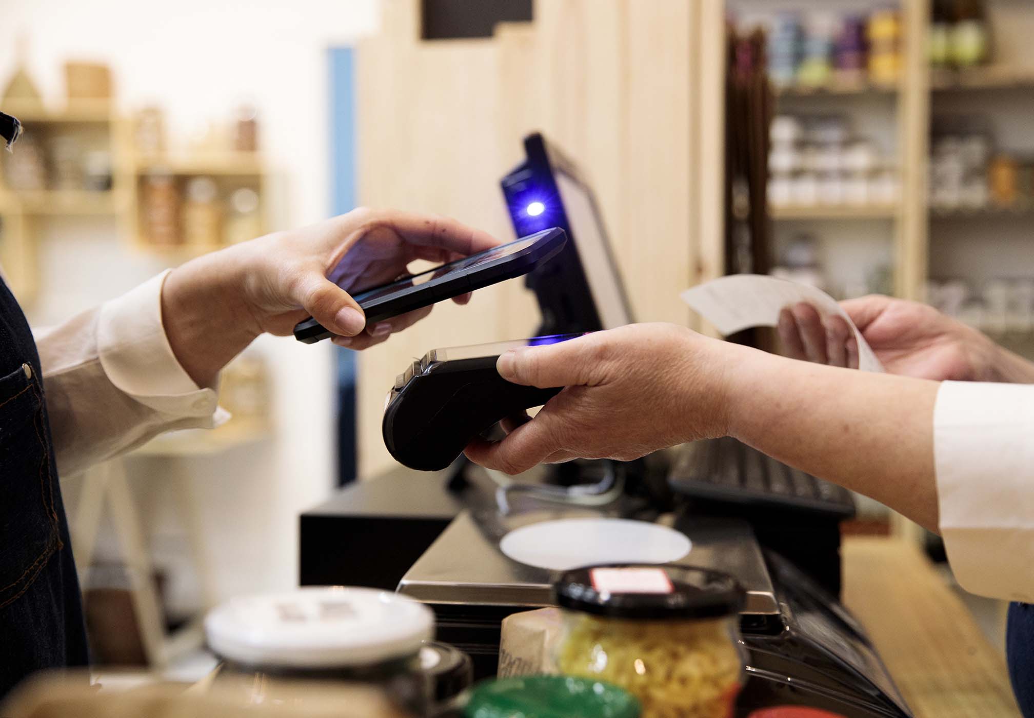 A woman making a payment at a store with her digital wallet. 