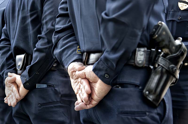 back of police officers with hands behind back