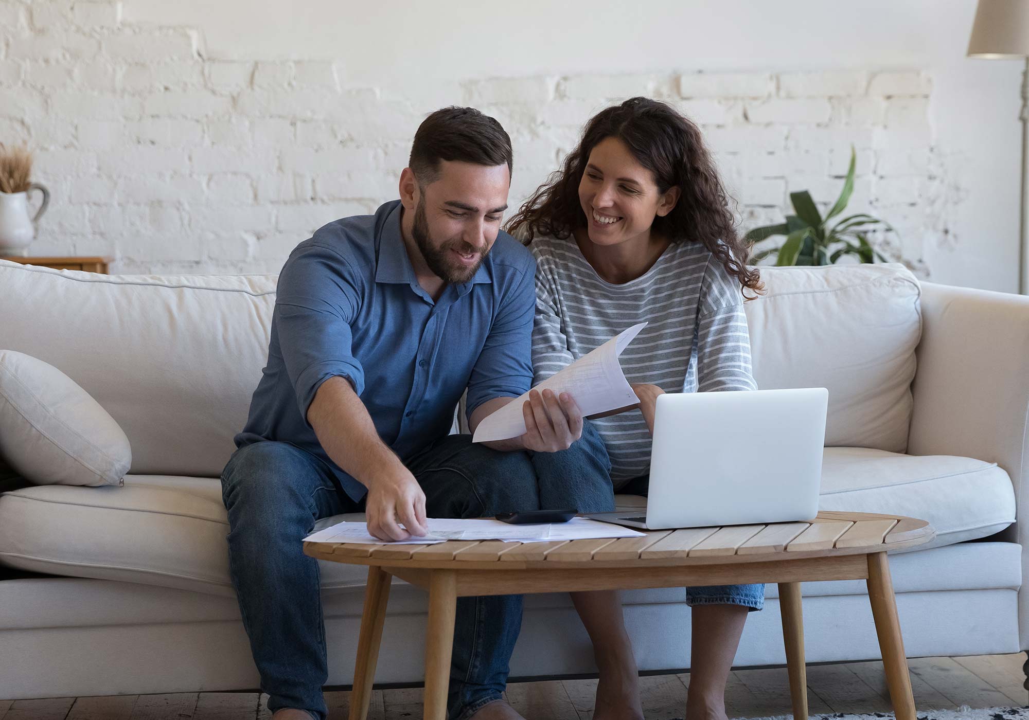 couple sitting on sofa looking at bank statements