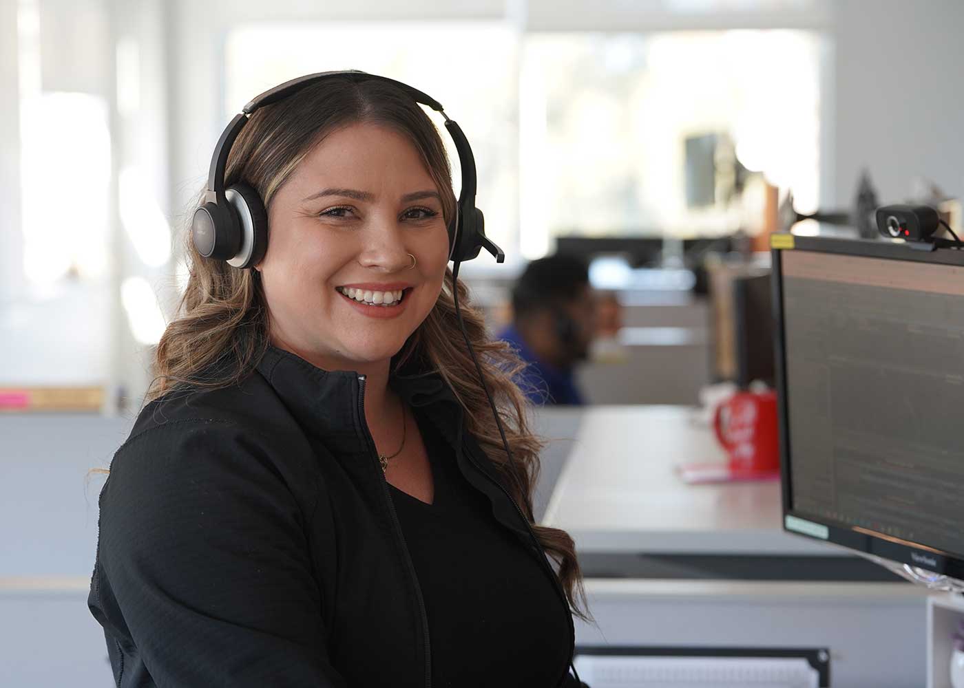 The Police Credit Union Contact Center Representative wearing headset and smiling. 