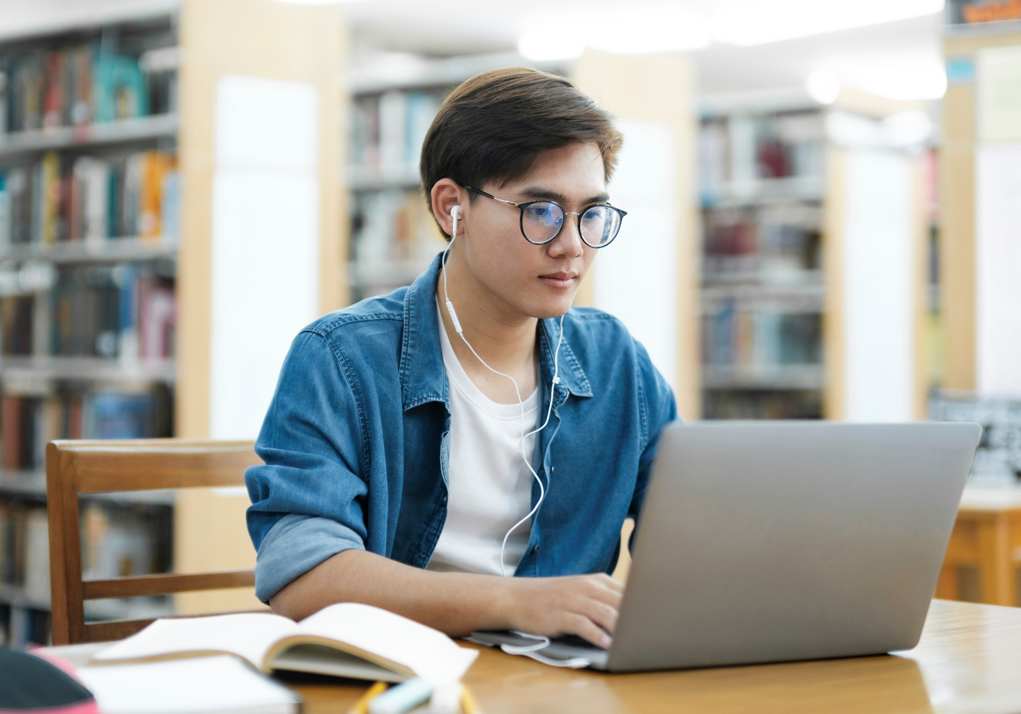 Man using a laptop in the library to access free Wi-Fi.