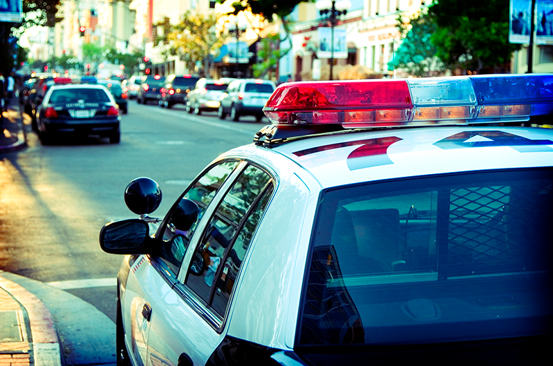 A police car parked on a busy street